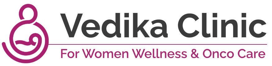 Logo of Vedika Clinic with a pink mother-and-child symbol and the tagline "For Women Wellness & Onco Care"